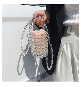 Clear acrylic pearl bucket bag with pink satin pouch shown being carried by hand