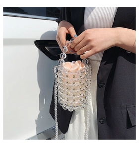 Detail of beaded acrylic bucket bag with gold studs and a pink satin inner drawstring pouch