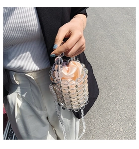 Detail of transparent acrylic beaded bucket bag with pink satin drawstring pouch and strap