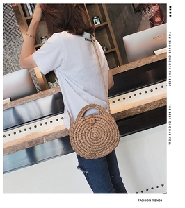 Detail of round straw beach bag with woven shoulder strap and bohemian circular texture