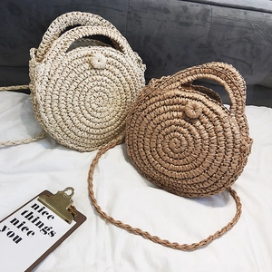 Detail of round straw bag showing intricate spiral weaving and woven button closure