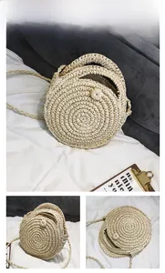 Detail of a beige handmade round straw bag showing the woven texture and sphere clasp