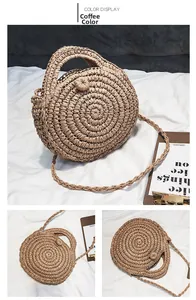 Detailed view of coffee brown round woven straw bag with adjustable shoulder strap and ring handles