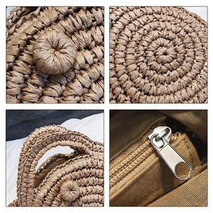 Detailed macro view showing concentric woven patterns and silver zipper on straw bag