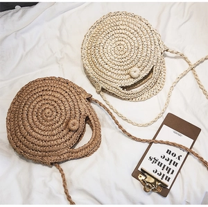 Detailed top view of handmade round straw bags with spiral texture and button closure