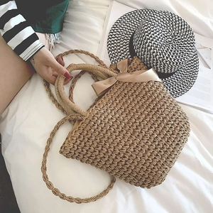 Detail of hand-woven straw bag featuring champagne silk bow and durable round handles