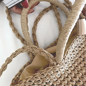 Detail of natural woven straw bag featuring rustic texture and smooth brown lining