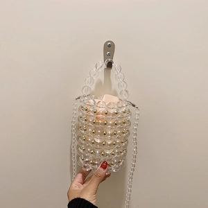 Handmade clear acrylic cylinder bag with pearl beads and gold metal accents on handle