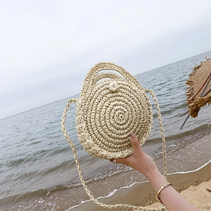 Handmade round beige straw beach bag with spiral texture for summer holidays