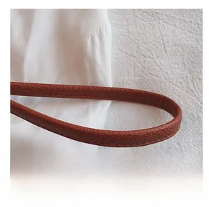 Nahaufnahme des braunen Lederriemens mit Litschi-Muster und feinen Nähten