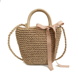 Handwoven straw beach bag with round handles, pink satin bow and long shoulder strap