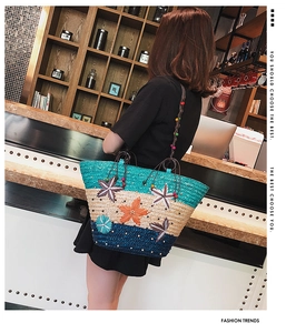 Close-up of tricolor straw tote bag with floral applique and beaded shoulder strap