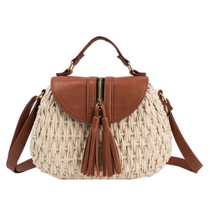 Sac de plage en paille avec garniture en cuir brun et glands décoratifs, vue de face