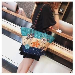 Detail of tricolor straw beach bag with woven 3D flowers and beaded shoulder strap