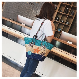 Detail of handwoven straw tote with colorful floral appliqués and beaded rope handle