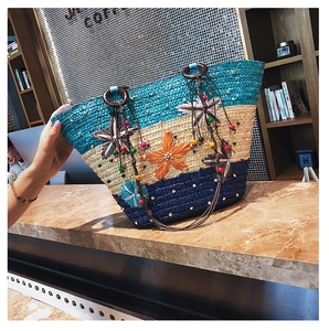 Detail of straw woven beach bag with starfish decor and contrast color block design