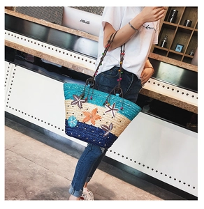 Detail of straw tote bag featuring colorful wood beads and 3D fabric flower decor