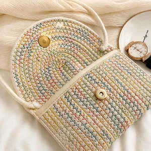 Détail du fermoir magnétique doré sur un sac à bandoulière tressé coloré pour femme