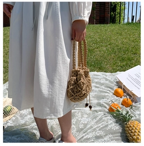 Dettaglio della borsa a secchiello intrecciata con corda di cotone e coulisse con perline