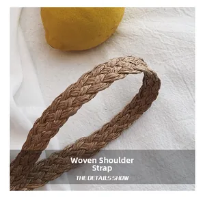 Détail d'une bandoulière tressée à la main en paille beige sur un sac de plage rustique