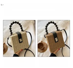 Detail of straw crossbody bag showing fine weave texture and black beaded handle