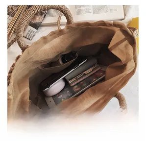 Détail de l'intérieur spacieux du sac de plage tressé avec doublure et articles du quotidien