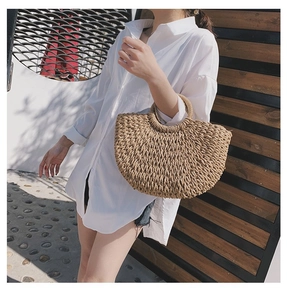 Détail du sac en paille tressé avec poignée anneau et texture de fibres naturelles