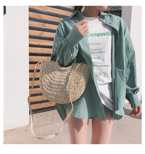 Détail du sac bandoulière demi-lune en paille tressée avec anses pour vacances à la plage