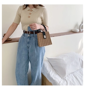 Straw mini handbag with black beaded handle and silver buckle shown with summer outfit
