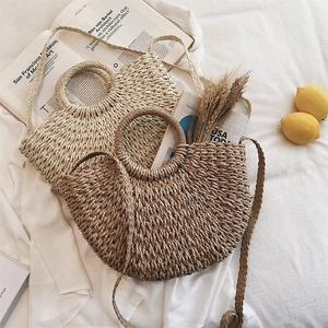 Vue à plat de sacs en paille faits main en beige et marron avec bandoulières pour la plage