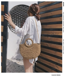 Vue macro d'un sac de plage tressé en paille au design demi-lune et poignée ronde