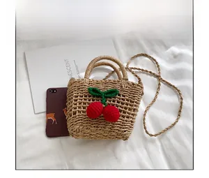 Detailed close-up of straw woven bag featuring 3D cherry accents and textured finish