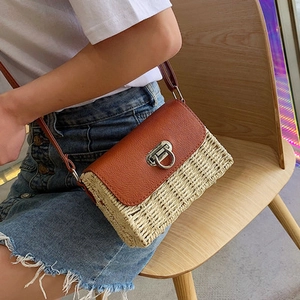 Vue détaillée du sac en paille avec rabat en cuir marron et fermoir rotatif en métal