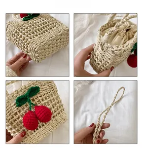 Detail view of woven cherry straw bag featuring hollow knit patterns and drawstring liner