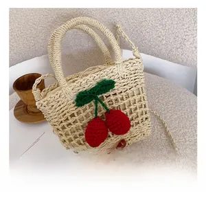 Detailed shot of handmade straw bag with 3D crochet cherries and drawstring closure