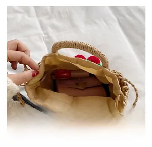 Detail showing inner capacity of straw bucket bag with drawstring liner and makeup