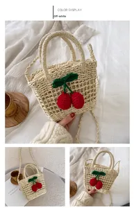 Detailed close-up of straw woven bag with red cherry accents and drawstring inner pouch