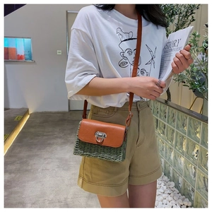 Détail du sac bandoulière vintage en paille avec rabat en cuir marron et texture verte
