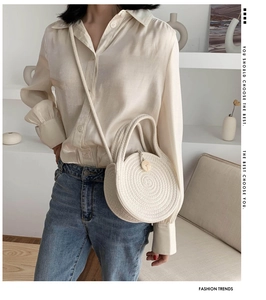 Detail of round woven straw bag with spiral texture and crossbody strap for summer