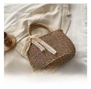 Detail of straw woven handbag with white lace bow on a stylish beige blazer