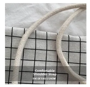 Close-up of thick woven cotton rope shoulder strap on a black and white checkered bag