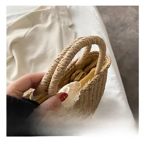 Detail of straw woven tote bag featuring round handles and a decorative white lace ribbon
