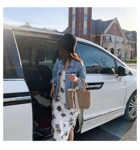 Straw tote bag with white lace bow detail paired with a floral maxi dress for summer