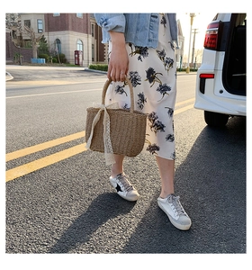 Detail of straw woven tote bag with white lace ribbon for beach vacation style