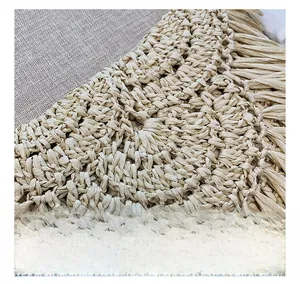 Close-up of handmade straw bag featuring dense weaving and elegant fringe tassels