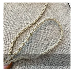 Close-up of the handcrafted woven shoulder strap texture on a summer straw beach bag