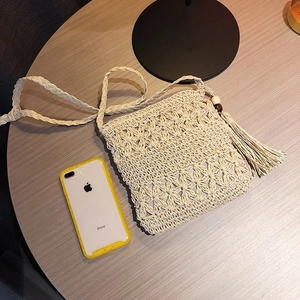 Détail d'un sac évidé tissé à la main avec glands latéraux et perles décoratives en bois