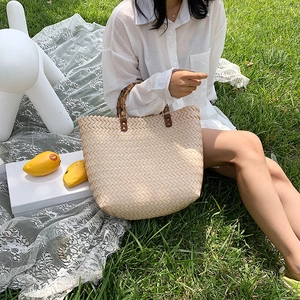 Grand sac cabas en paille tressée beige avec anses en bambou et détails en cuir