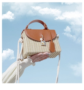 Detailed texture of straw woven square bag with brown leather flap and gold lock clasp