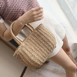 Dettaglio di una borsa tote in paglia fatta a mano beige chiaro con trama intrecciata